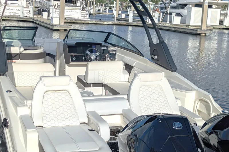 Slide: The Image of 2025 Sea Ray SDX 290 Outboard boat interior with luxurious seating at marina. - 2