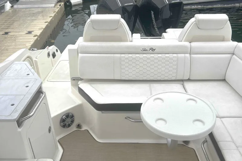 Slide: The Image of 2025 Sea Ray SDX 290 Outboard boat interior with white seating and round table. - 5