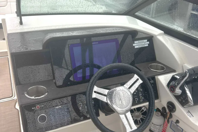 Slide: The Image of 2025 Sea Ray SDX 290 Outboard dashboard with steering wheel and navigation system. - 3
