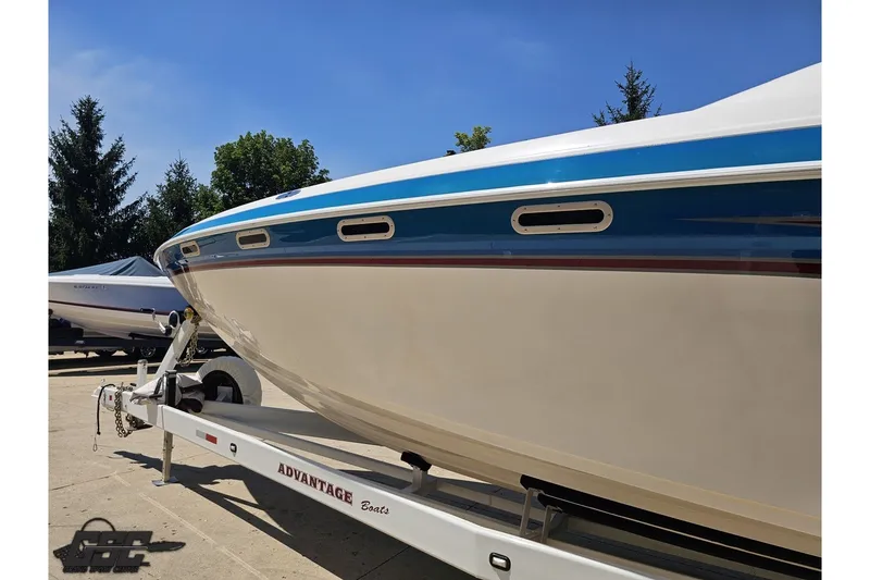 Slide: The Image of 2001 Advantage 34 Offshore boat on trailer, blue and white design, sunny day. - 20