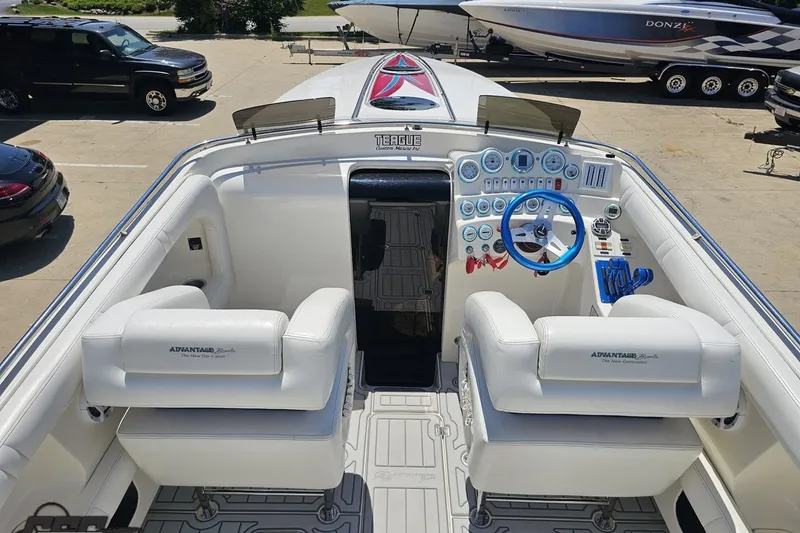 Slide: The Image of Interior of a 2001 Advantage 34 Offshore boat with white seating and blue steering wheel. - 41