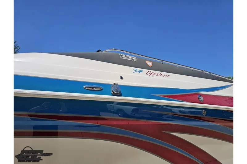 Slide: The Image of 2001 Advantage 34 Offshore boat with vibrant blue and red accents against a clear sky. - 19