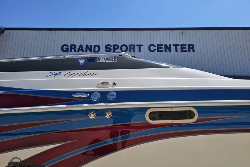 Slide: The Image of 2001 Advantage 34 Offshore boat at Grand Sport Center, featuring vibrant blue and red design. - 5