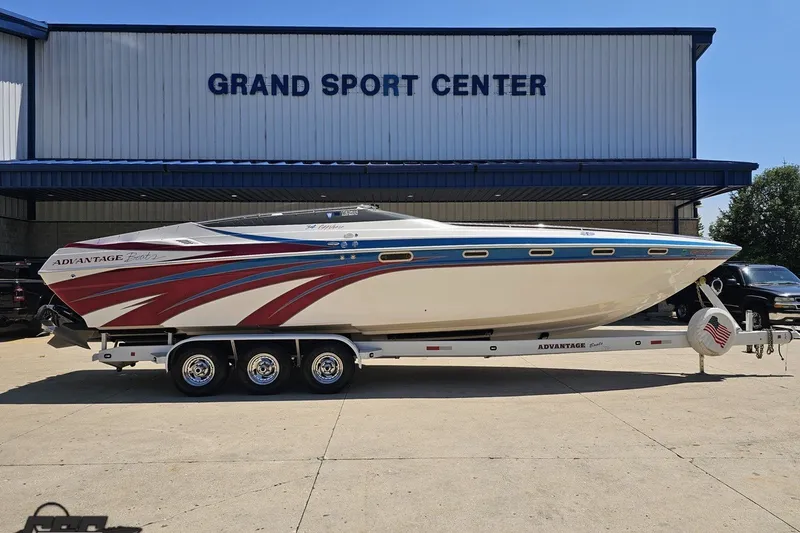 Slide: The Image of 2001 Advantage 34 Offshore boat on trailer at Grand Sport Center, featuring sleek design and vibrant graphics. - 2