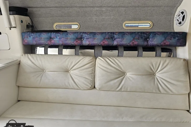 Slide: The Image of Interior of a 2001 Advantage 34 Offshore boat with cushioned seating and small windows. - 68