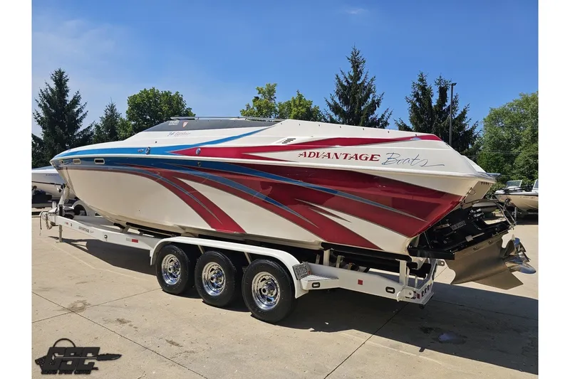 Slide: The Image of 2001 Advantage 34 Offshore boat with vibrant red and blue graphics on a trailer. - 22