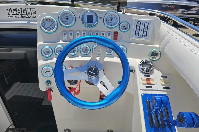 Slide: The Image of Control panel of a 2001 Advantage 34 Offshore boat with blue steering wheel. - 56