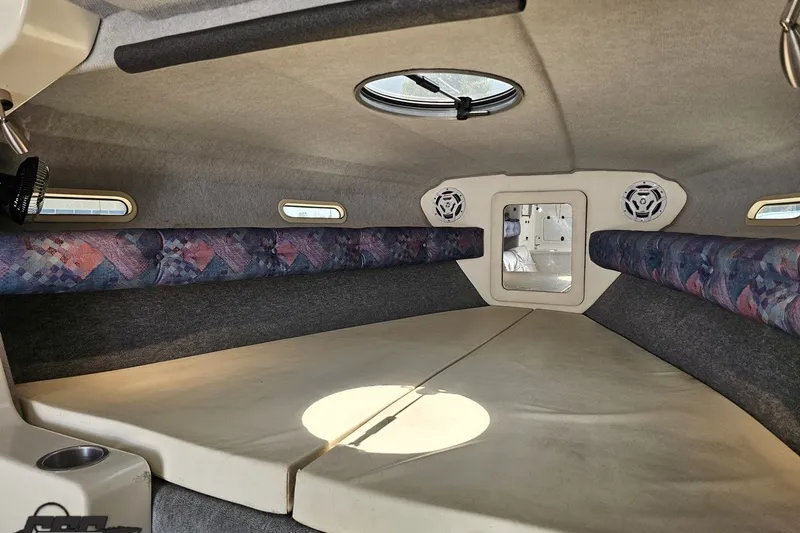 Slide: The Image of Interior cabin of 2001 Advantage 34 Offshore boat, featuring cushioned seating and circular windows. - 67