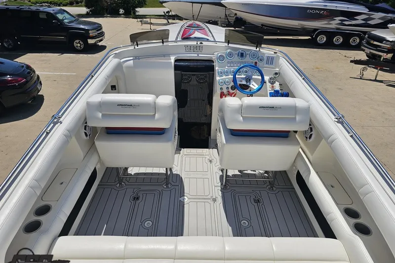 Slide: The Image of 2001 Advantage 34 Offshore boat interior with white seating and blue steering wheel. - 40