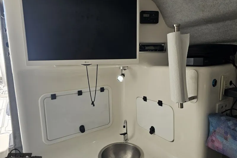 Slide: The Image of Interior of 2001 Advantage 34 Offshore boat with TV, sink, and storage compartments. - 70