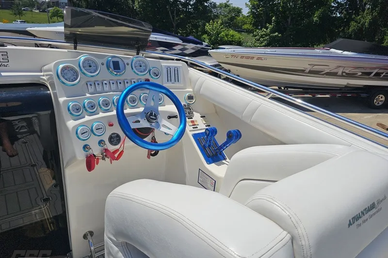 Slide: The Image of Interior of 2001 Advantage 34 Offshore boat with blue steering wheel and control panel. - 54