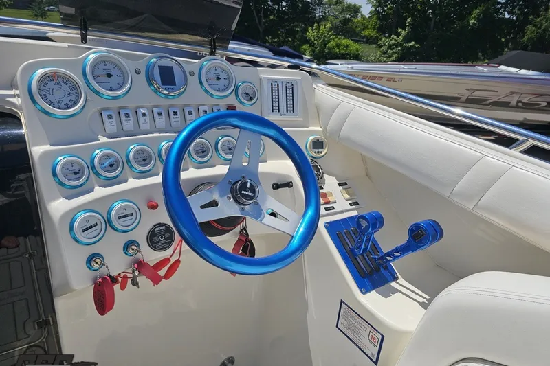 Slide: The Image of Cockpit of 2001 Advantage 34 Offshore boat with blue steering wheel and gauges. - 55