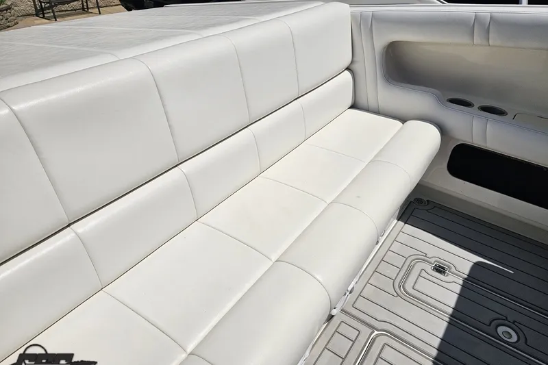 Slide: The Image of White leather seating on a 2001 Advantage 34 Offshore boat, featuring cup holders and deck flooring. - 48