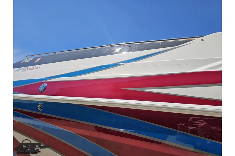 Slide: The Image of 2001 Advantage 34 Offshore boat with vibrant red and blue graphics under a clear blue sky. - 24