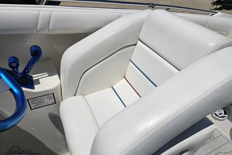 Slide: The Image of White leather boat seat with blue and red accents, featuring blue controls, in a 2001 Advantage 34 Offshore. - 53
