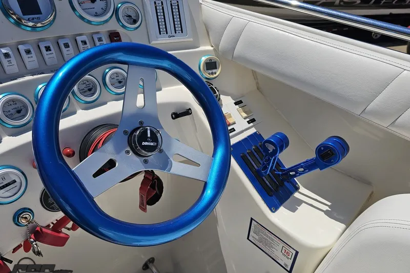 Slide: The Image of Steering wheel and controls of a 2001 Advantage 34 Offshore boat cockpit. - 57