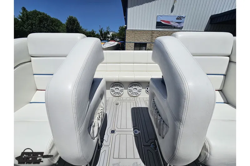 Slide: The Image of 2001 Advantage 34 Offshore boat interior with white seating and speakers, docked outdoors. - 76
