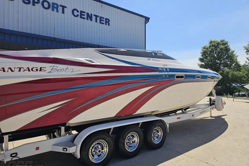 Slide: The Image of 2001 Advantage 34 Offshore boat with vibrant red and blue design on trailer. - 10