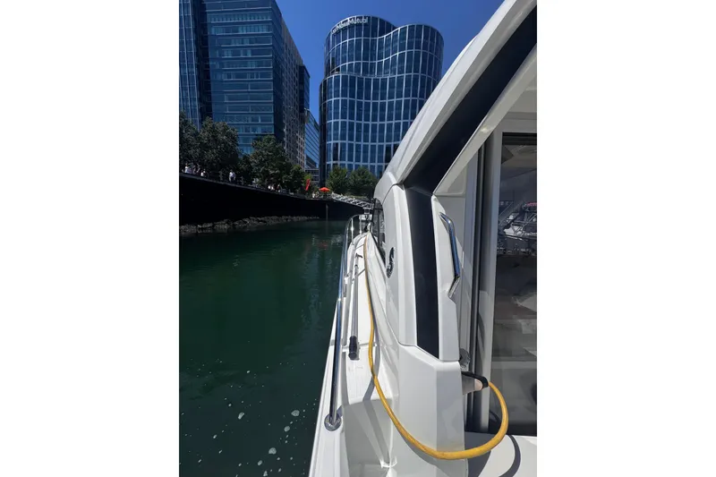 Slide: The Image of Beneteau Antares 8 (2021) docked near modern buildings, reflecting on calm water. - 26