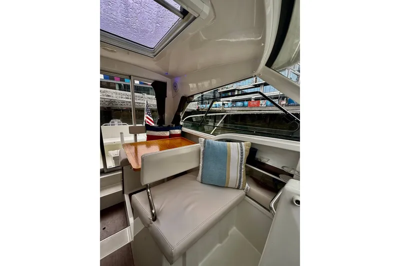 Slide: The Image of Interior of 2021 Beneteau Antares 8 boat with seating, table, and window view. - 5
