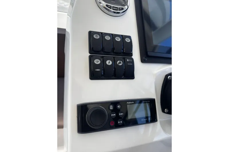 Slide: The Image of Control panel of a 2021 Beneteau Antares 8 boat with switches and Fusion audio system. - 19