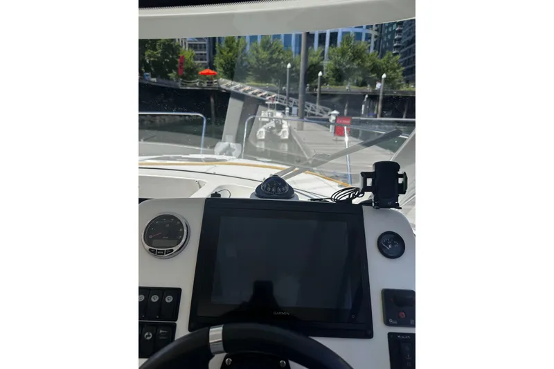 Slide: The Image of Cockpit view of 2021 Beneteau Antares 8, featuring navigation equipment and marina backdrop. - 17