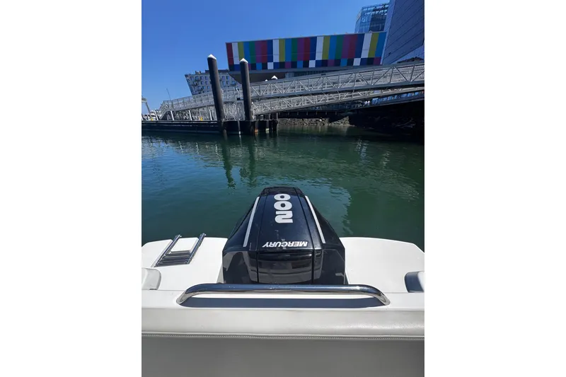 Slide: The Image of 2021 Beneteau Antares 8 with Mercury engine, docked near colorful waterfront building. - 21