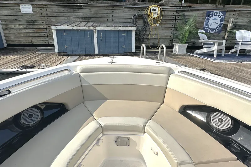Slide: The Image of 2025 Boston Whaler 280 Vantage boat interior with cushioned seating and speakers at dock. - 3