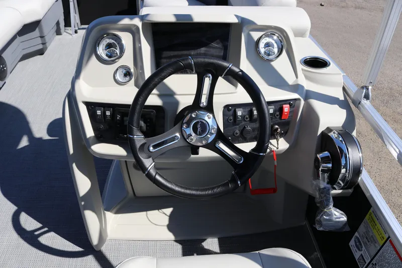 Slide: The Image of 2025 SunChaser Vista 20 Fish boat dashboard with steering wheel and control panel. - 13