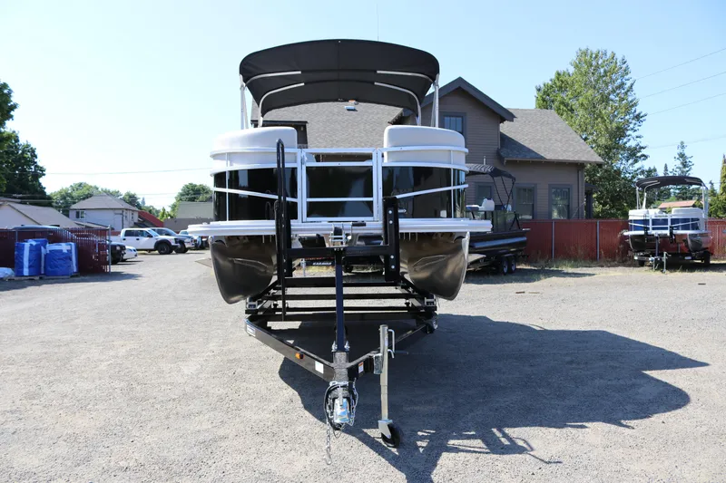 Slide: The Image of 2025 SunChaser Vista 20 Fish pontoon boat on trailer, parked outdoors. - 2