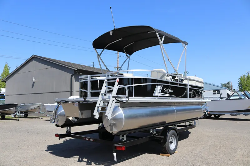 Slide: The Image of 2025 SunChaser Vista 20 Fish pontoon boat on trailer, parked outdoors under clear blue sky. - 4