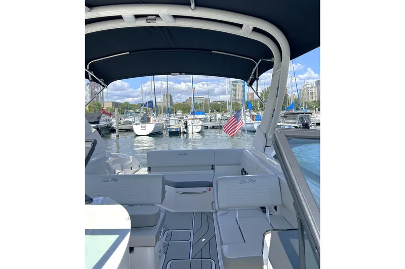 Slide: The Image of 2025 Sea Ray SDX 270 Surf boat interior with marina view and American flag. - 5