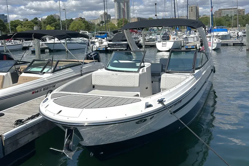 Slide: The Image of 2025 Sea Ray SDX 270 Surf boat docked at a marina, showcasing sleek design and modern features. - 1