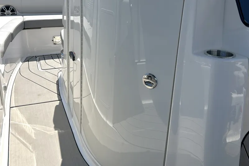 Slide: The Image of 2025 Sea Ray SDX 270 Surf boat interior with sleek white design and seating area. - 10