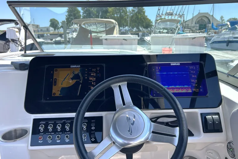 Slide: The Image of 2025 Sea Ray SDX 270 Surf dashboard with dual Simrad displays at marina. - 13