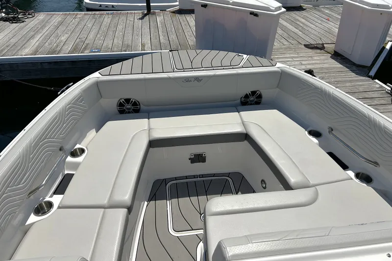 Slide: The Image of 2025 Sea Ray SDX 270 Surf boat interior with cushioned seating and cup holders. - 4