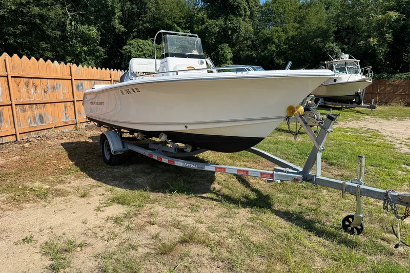 The Image of 2016 Sea Hunt Triton 188 boat on trailer, parked outdoors near wooden fence. - 0