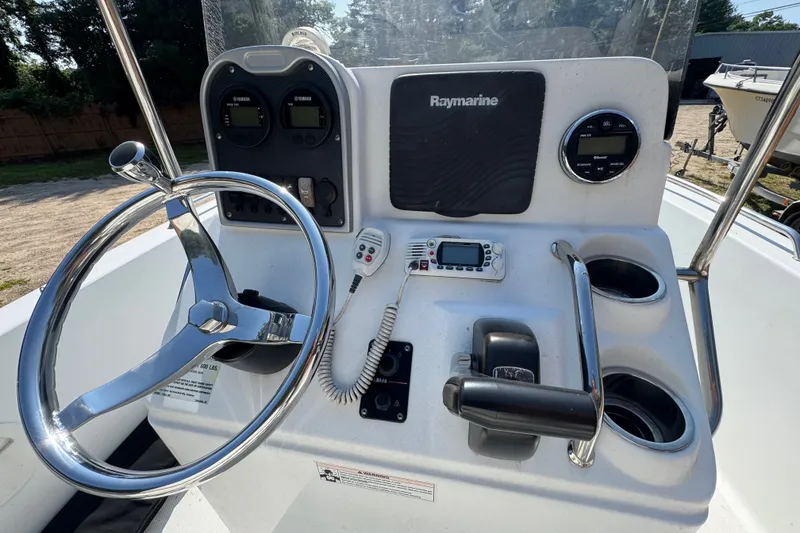 Slide: The Image of 2016 Sea Hunt Triton 188 boat console with steering wheel, Raymarine display, and controls. - 5
