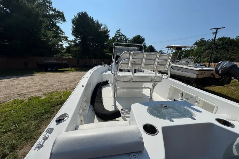 Slide: The Image of 2016 Sea Hunt Triton 188 boat interior with seating and console, parked outdoors. - 7