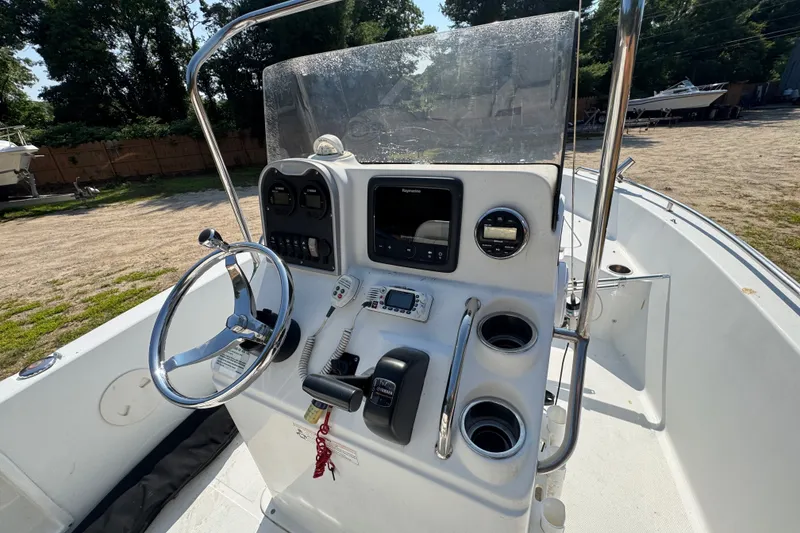 Slide: The Image of 2016 Sea Hunt Triton 188 boat console with steering wheel and navigation equipment. - 8