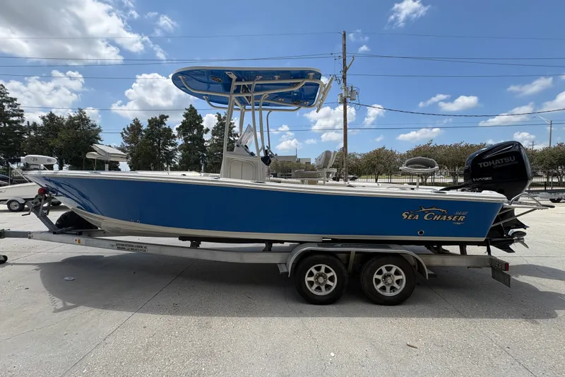 Slide: The Image of 2019 Sea Chaser 26 LX boat on trailer, blue hull, Tohatsu engine, sunny day. - 6