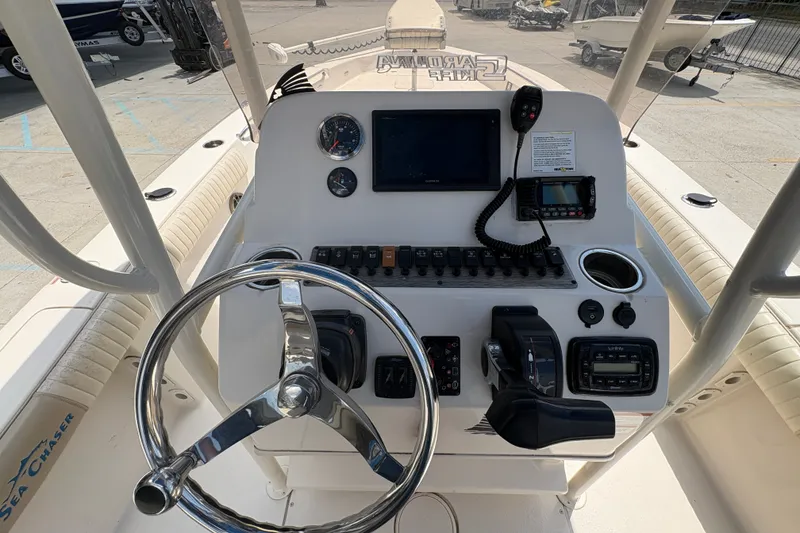 Slide: The Image of 2019 Sea Chaser 26 LX boat dashboard with steering wheel and navigation controls. - 16