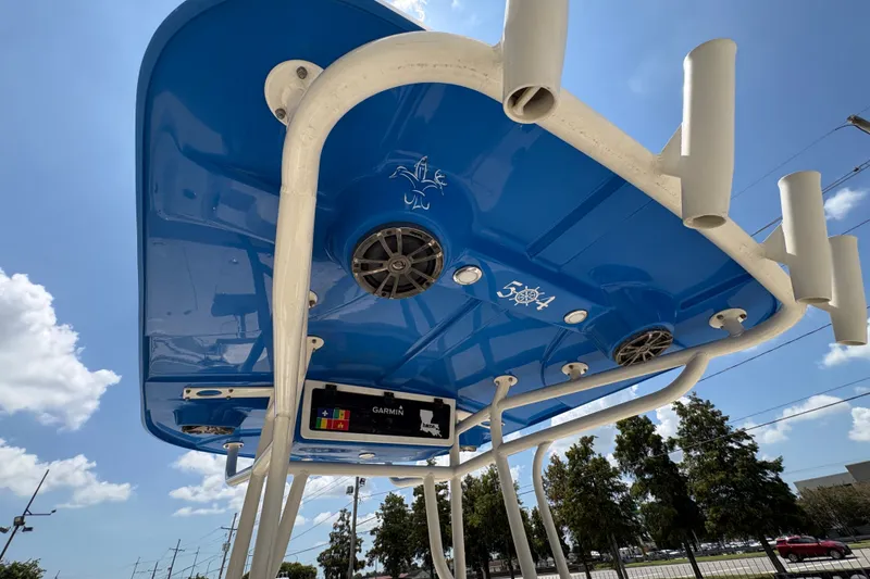 Slide: The Image of 2019 Sea Chaser 26 LX boat canopy with speakers and rod holders under a clear blue sky. - 21