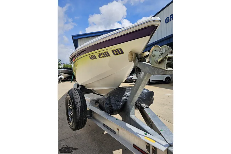 Slide: The Image of 2007 Sunsation 32 Dominator boat on trailer, parked outdoors under a blue sky. - 14