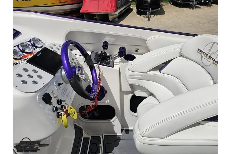 Slide: The Image of Interior of a 2007 Sunsation 32 Dominator boat with white seating and purple accents. - 54