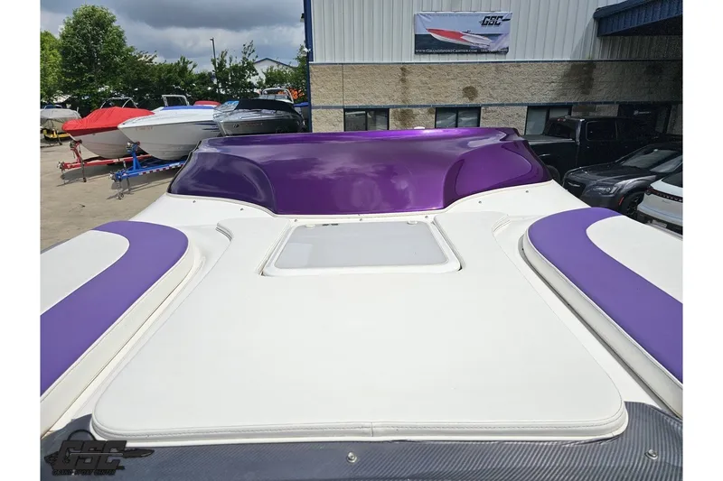 Slide: The Image of 2007 Sunsation 32 Dominator boat with purple and white detailing, parked outdoors. - 86