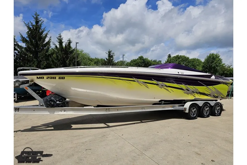 Slide: The Image of 2007 Sunsation 32 Dominator speedboat on trailer, vibrant yellow and purple design. - 18