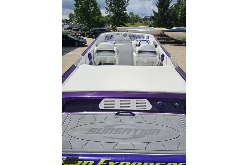 Slide: The Image of 2007 Sunsation 32 Dominator boat with sleek white and purple interior, docked outdoors. - 35