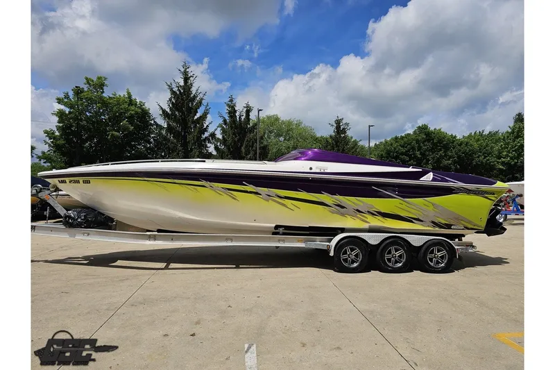 Slide: The Image of 2007 Sunsation 32 Dominator boat with vibrant yellow and purple design on a trailer. - 20