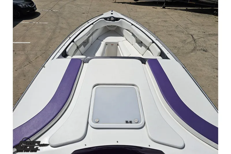 Slide: The Image of 2007 Sunsation 32 Dominator boat with white and purple seating, docked on concrete. - 63